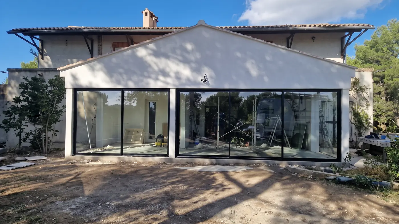 Grandes baies vitrées en aluminium noir sur l'extension d'une villa du Pays d'Aix