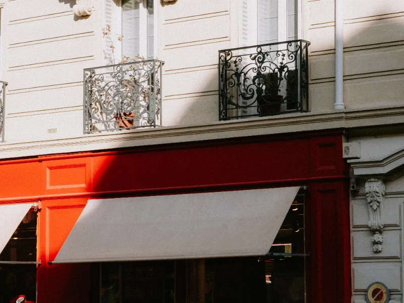 Devanture de commerce avec store banne rouge et vitrine