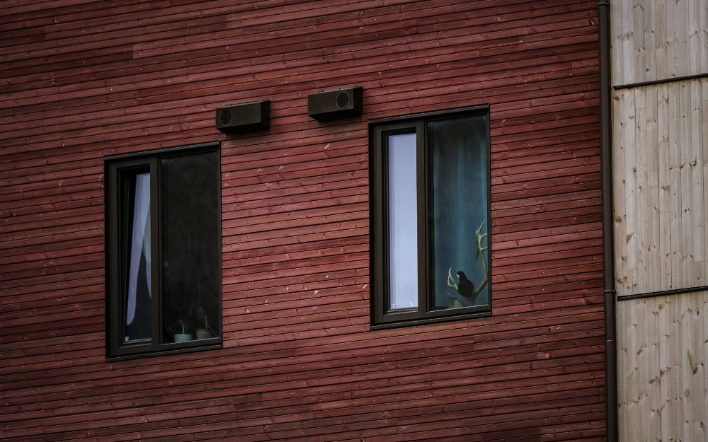 Fenêtres à cadre aluminium noir sur une façade en bois