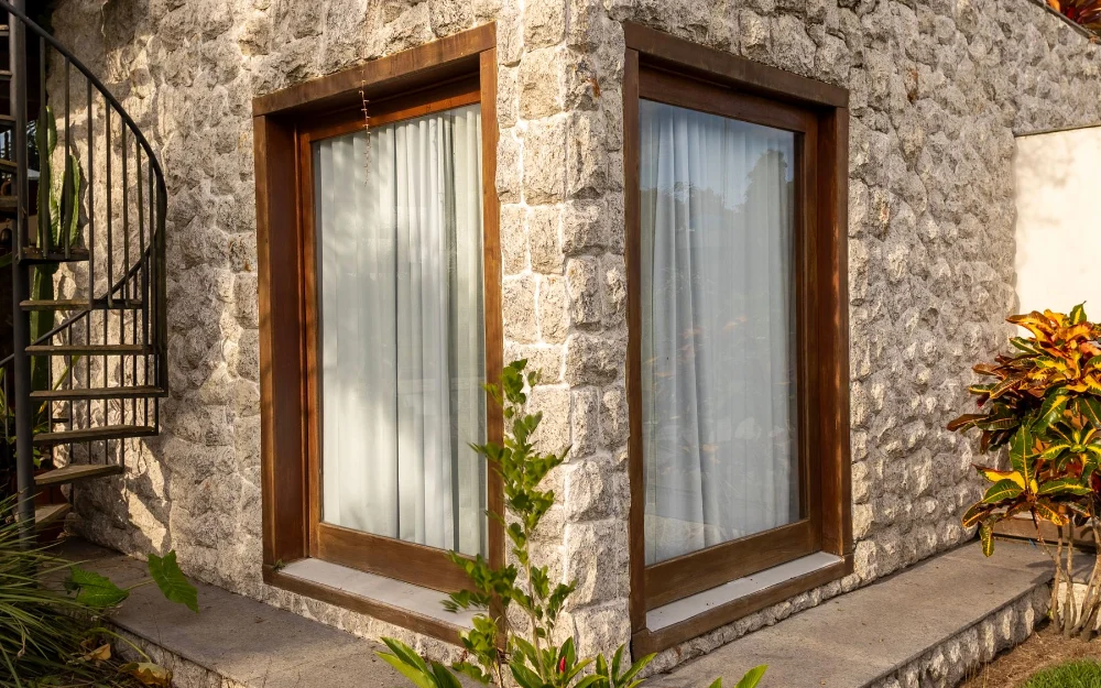 Fenêtre d'angle à cadre bois dans un mur en pierre