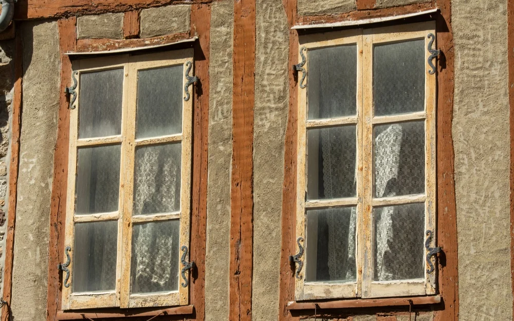 Fenêtres en bois anciennes à la peinture écaillée, avant rénovation