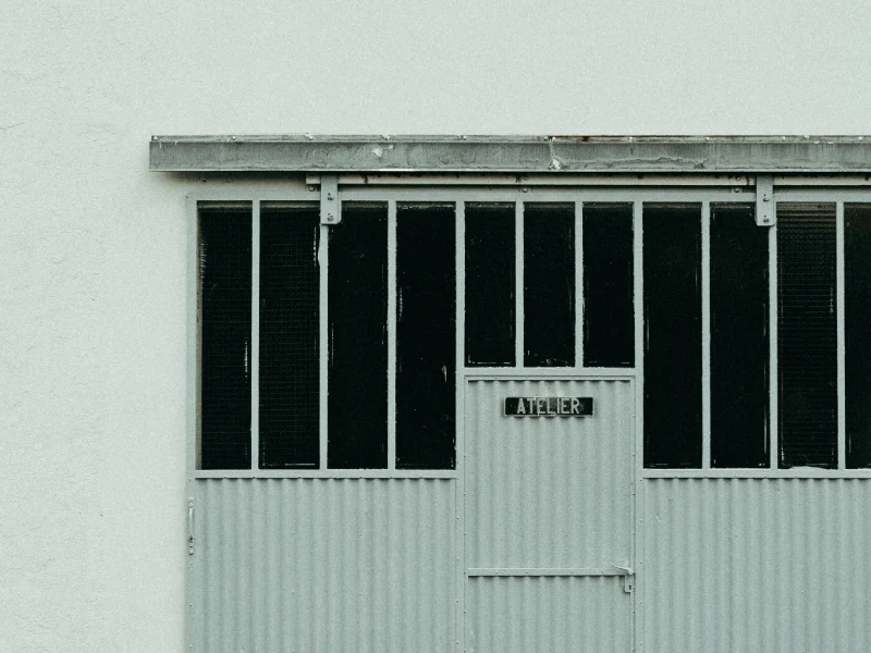 Grille de protection métallique posée devant la vitrine d'un atelier