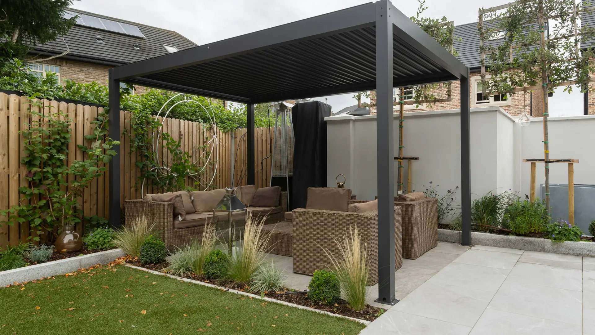 Pergola bioclimatique en aluminium anthracite à lames orientables au-dessus d'une terrasse