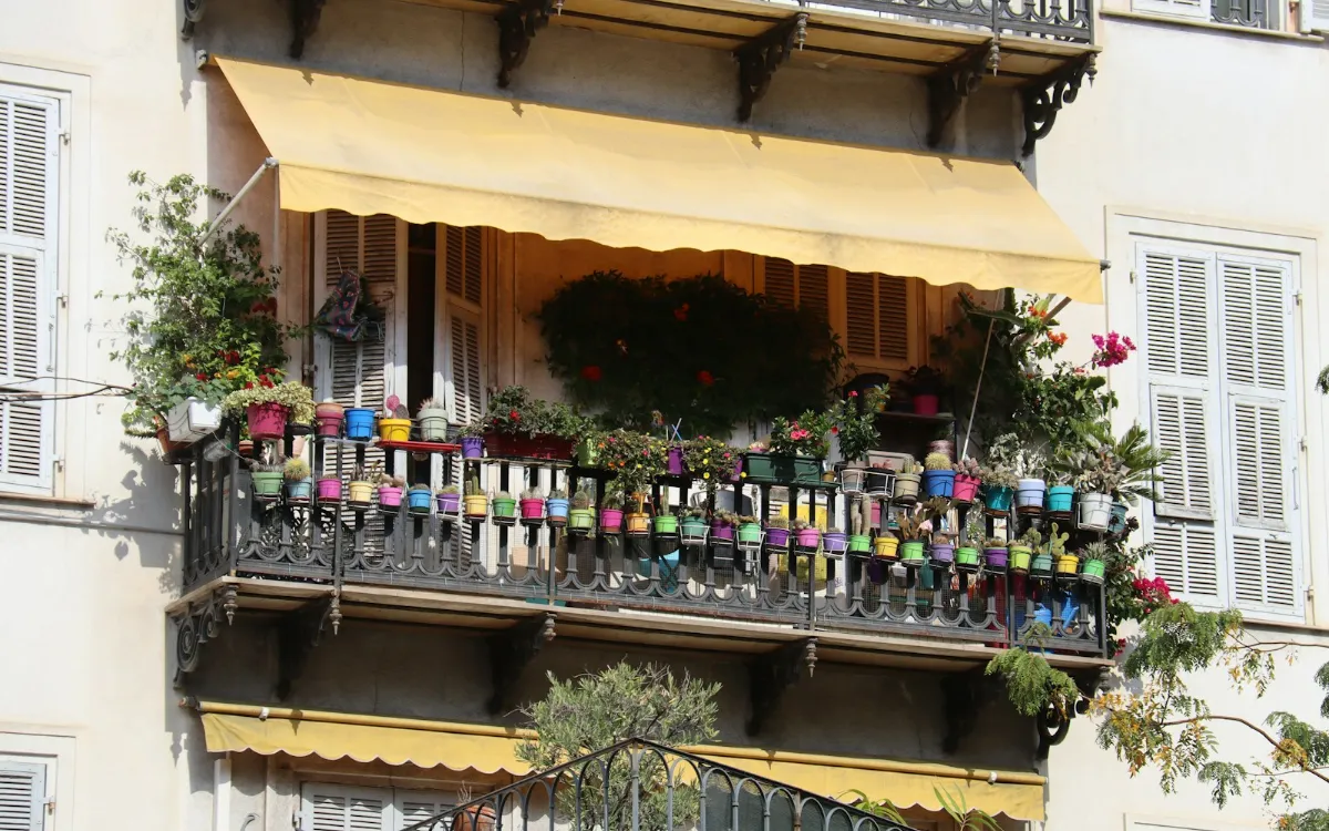 Store banne semi-coffre déployé sur une terrasse fleurie