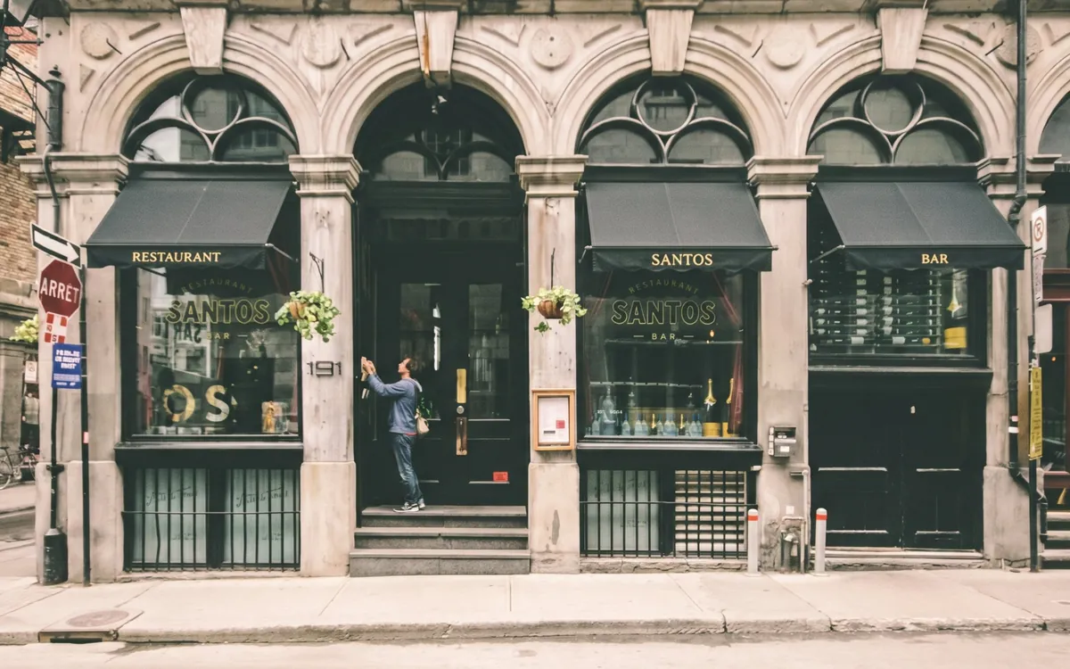 Stores bannes noirs posés sur la devanture d'un restaurant bar en pierre