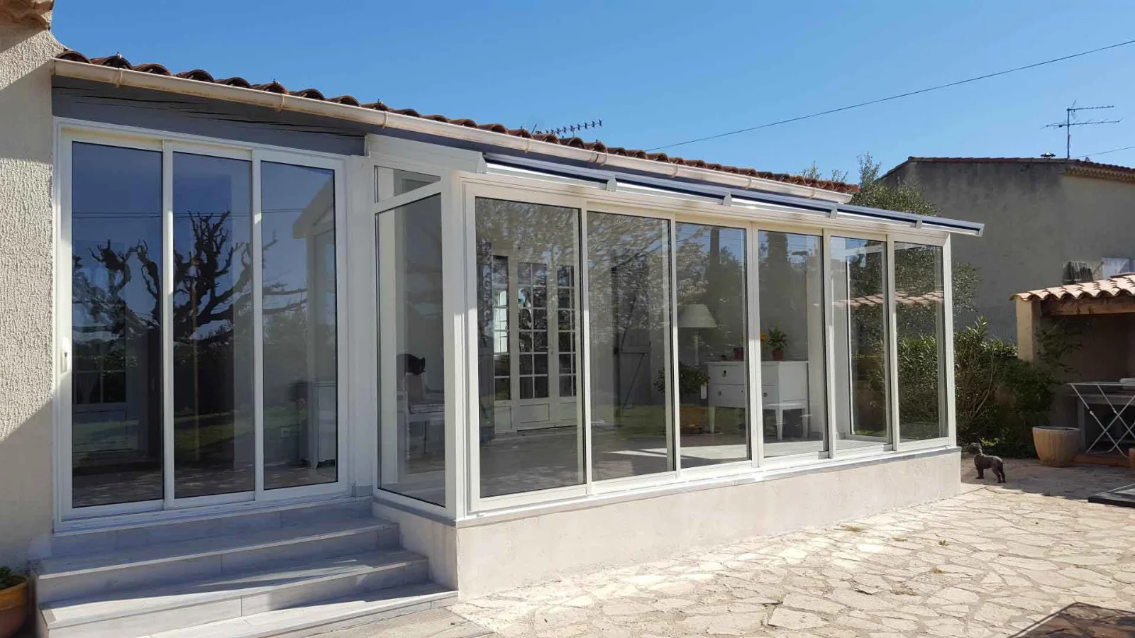 Véranda aluminium blanche montée sur un jardin
