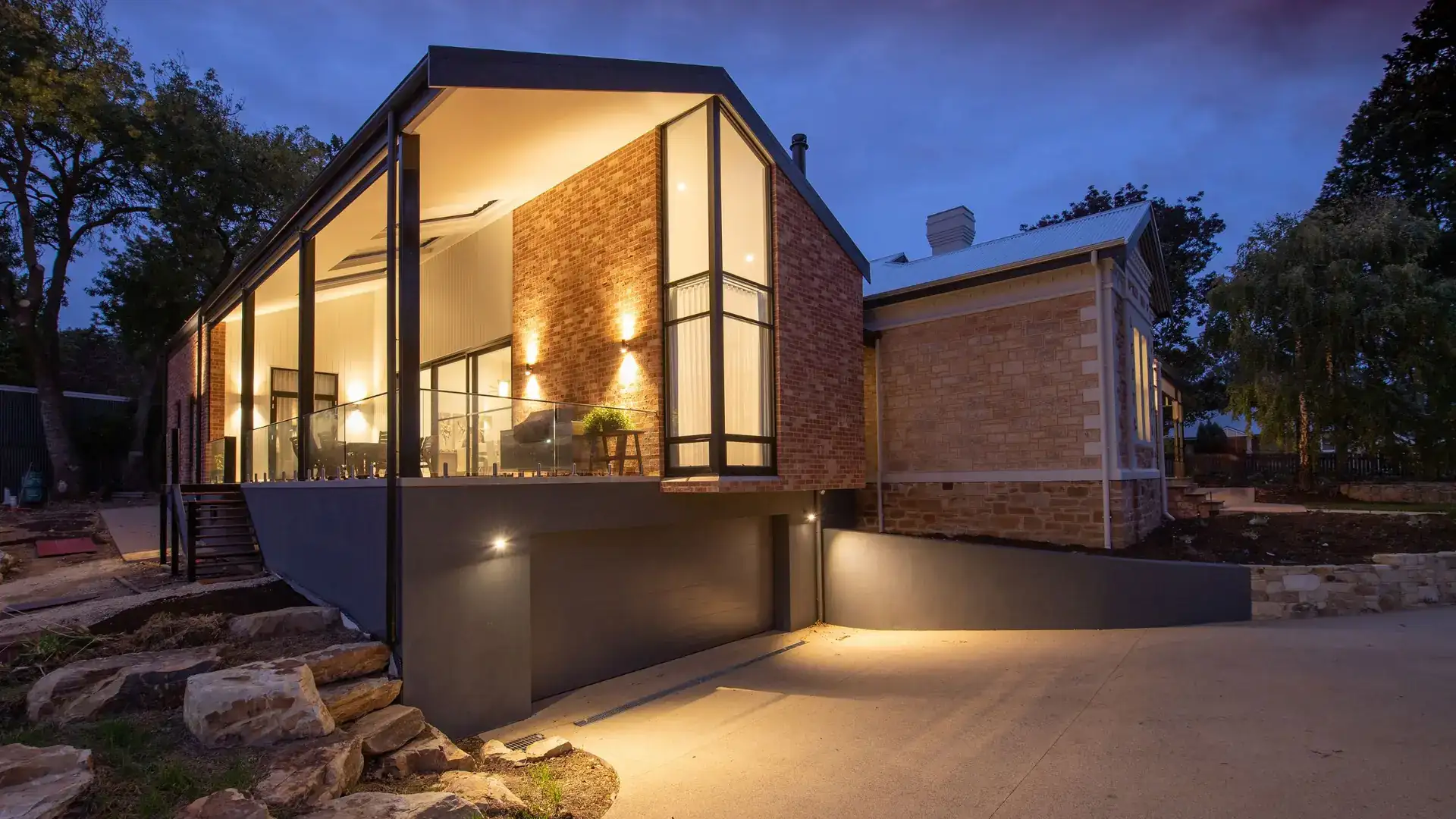 Villa aux grandes menuiseries aluminium éclairée à la nuit tombée